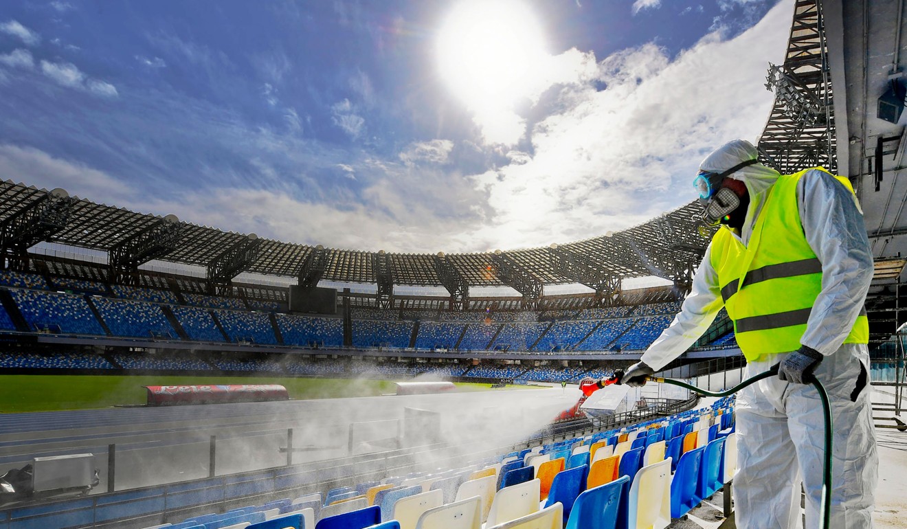 A cleaner wearing a protective suit sprays disinfectant at San Paolo stadium in Naples, Italy. Photo: AFP