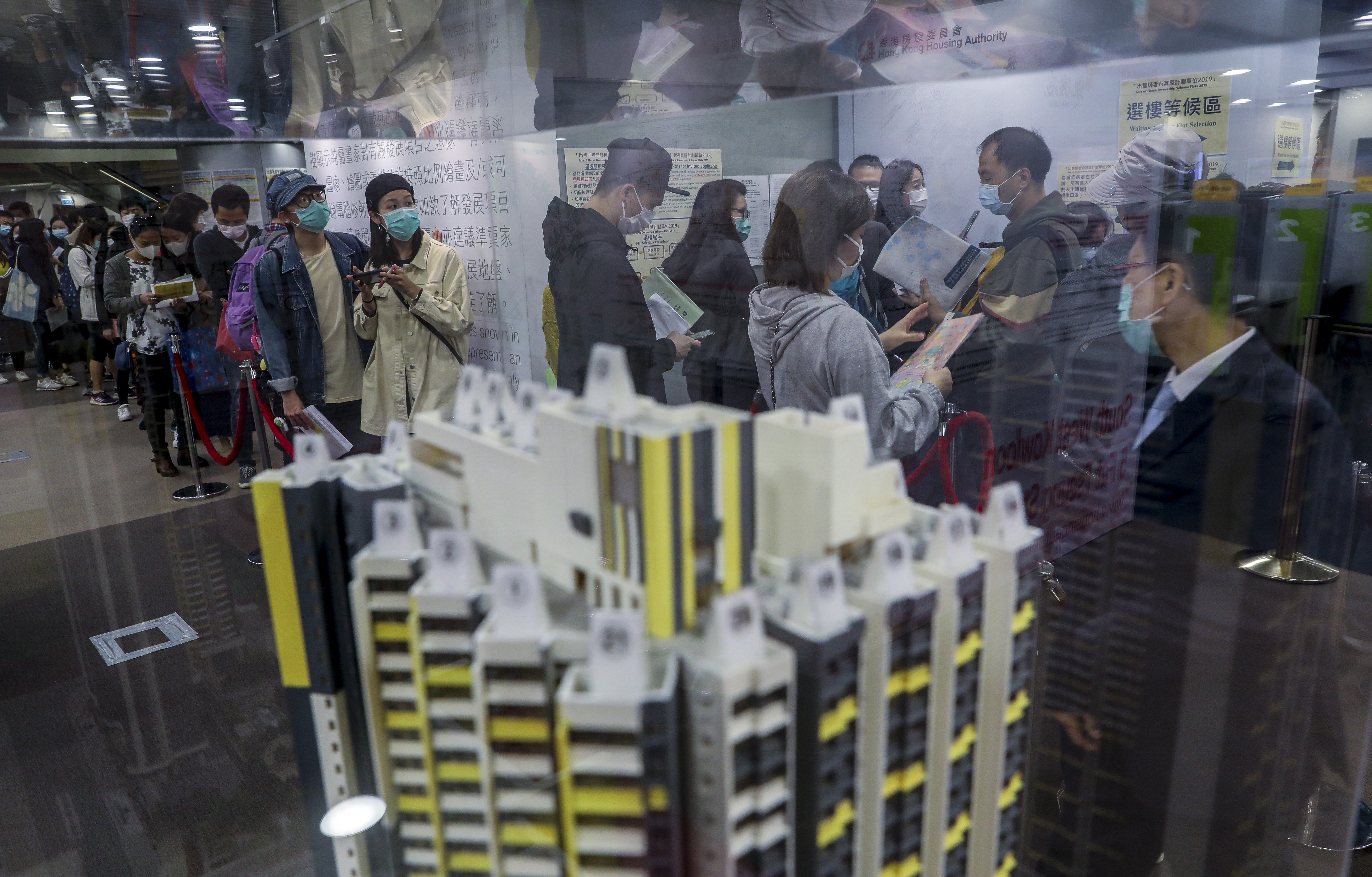 Potential homebuyers wearing protective face masks look at a scale model of Home Ownership Scheme flats in Lok Fu, Hong Kong, amid the novel coronavirus epidemic. Photo: Winson Wong