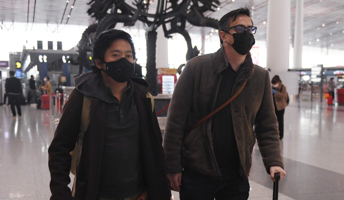 Wall Street Journal reporters Philip Wen (left) and Josh Chin walk through Beijing Capital Airport after being kicked out of the country on February 24. Photo: AFP