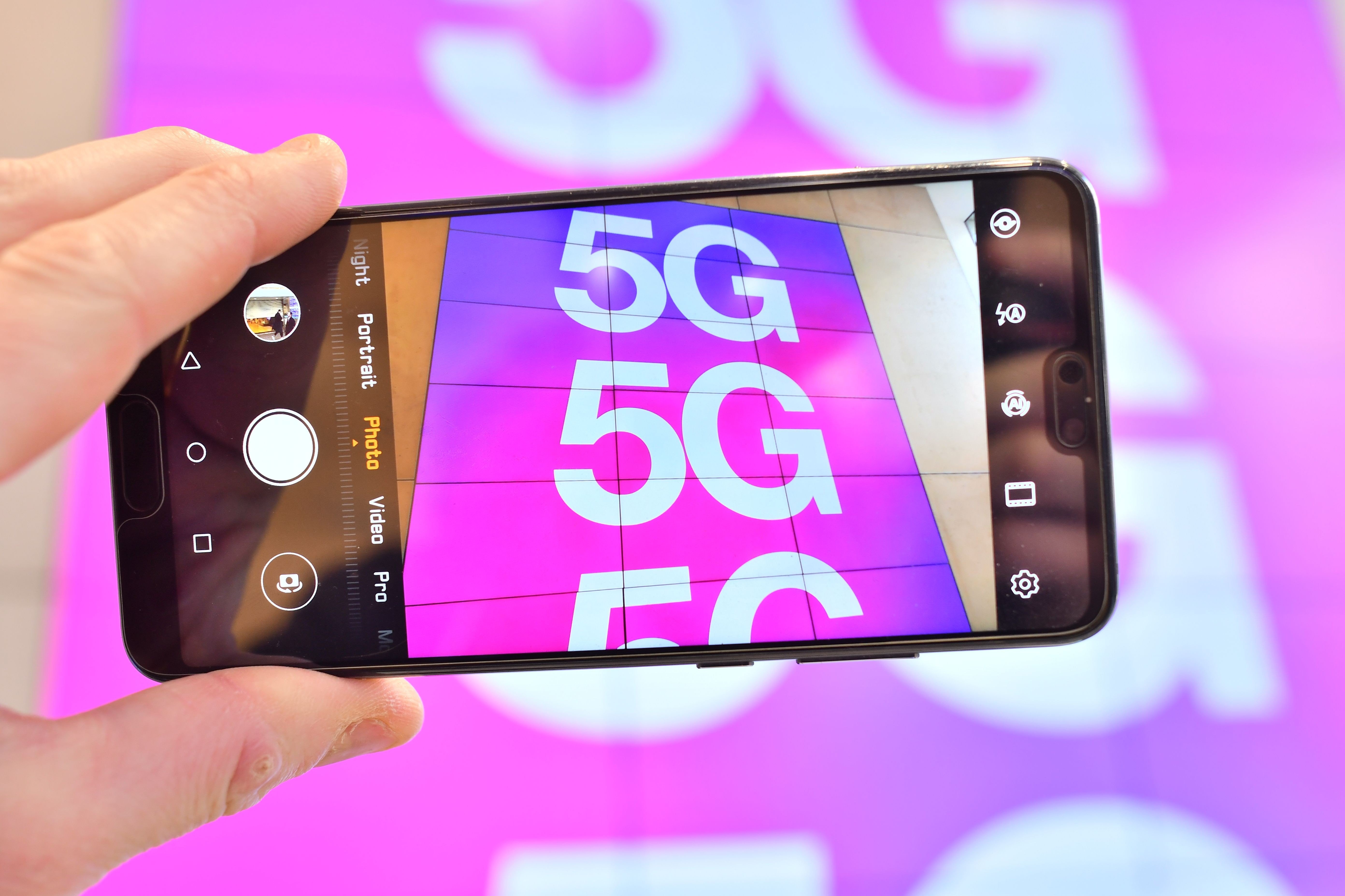 A mobile phone camera shows a sign advertising 5G in a shop in London on January 28, 2020. Photo: AFP