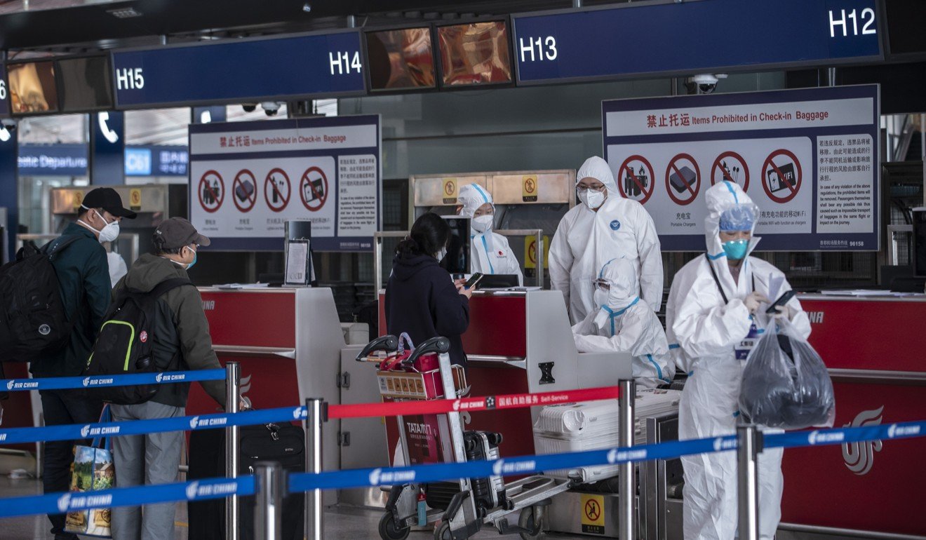 Airport employees in protective suits at Beijing’s Capital Airport. Photo: Bloomberg