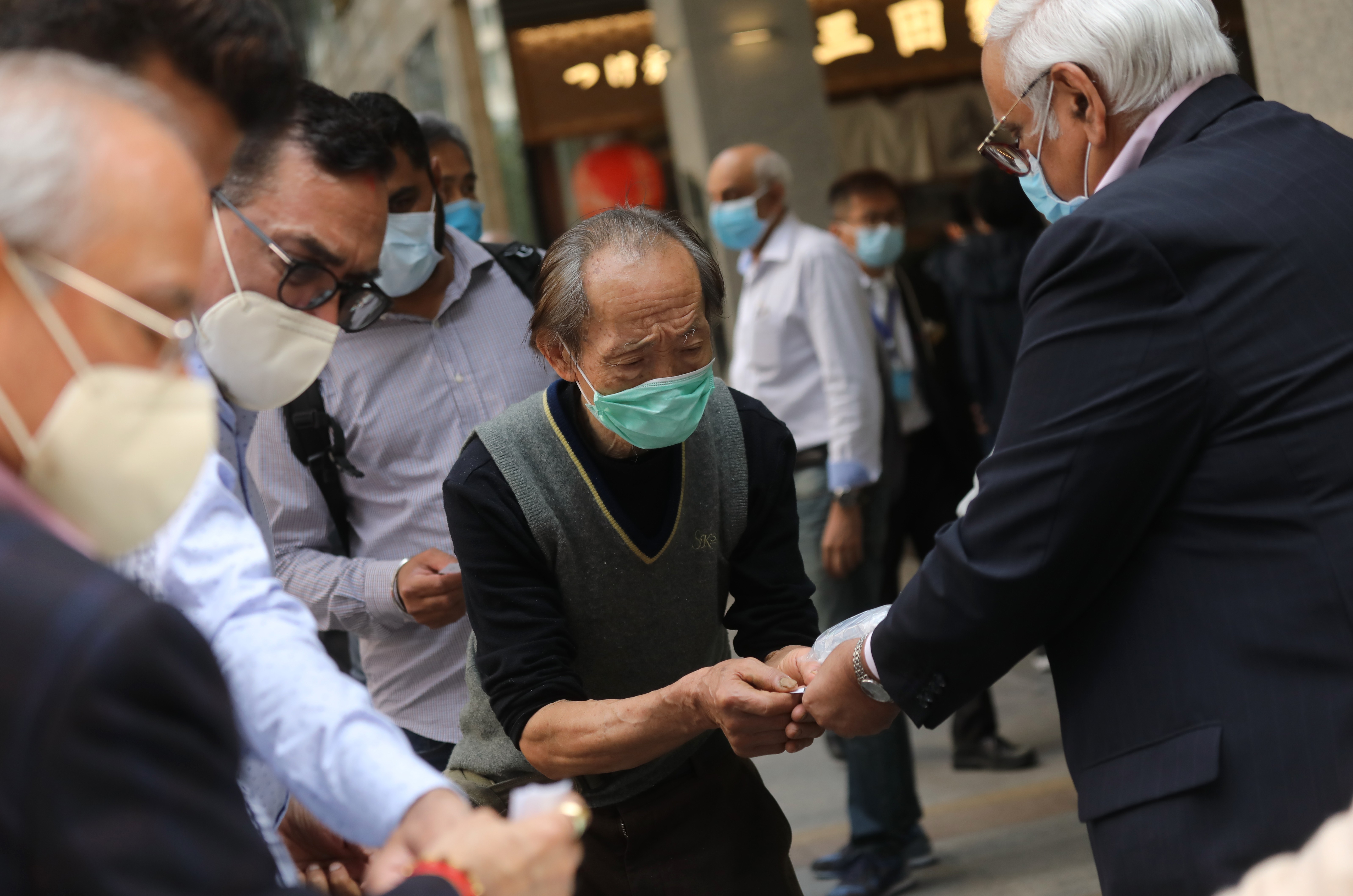 Members of a Hindu temple and non-profit organisation distribute free face masks and hand sanitiser to citizens over 60 in Tsim Sha Tsui on March 10. As the government scrambled to secure the supply of face masks, various groups used their own means to source and distribute them. Photo: K.Y. Cheng