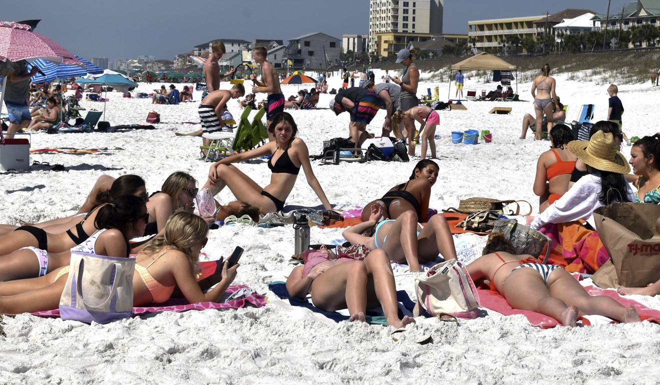 Students lie on the beach during spring break at Miramar Beach, Florida, on March 16. Speaking about the coronavirus, Ellis Turner said, ‘I feel safer here than at school,’ noting they live in a residential hall there, where everybody is touching the same stuff. Photo: AP