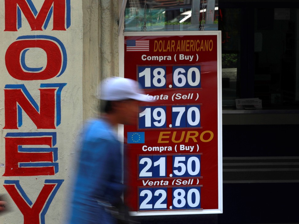 A man walks past a board displaying the exchange rates for the Mexican peso, US dollar and other currencies in Mexico City on March 17. The surge in the value of the US dollar is a major threat to emerging markets. Photo: Reuters