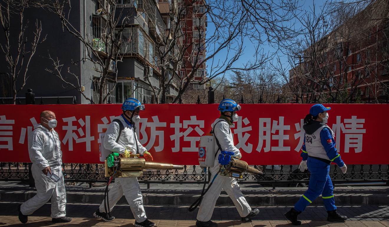 epa08291466 Members of the Blue Sky Rescue team walk with their equipment after disinfection of a residential area as a precaution against the spread of the coronavirus in Beijing, China, 13 March 2020. The World Health organization (WHO) officially declared the coronavirus outbreak a pandemic on 11 March 2020. EPA-EFE/ROMAN PILIPEY