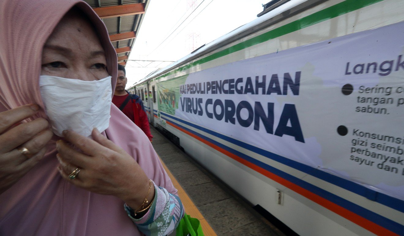 A rail passenger wears a mask to guard against the coronavirus in West Java, Indonesia. Photo: EPA