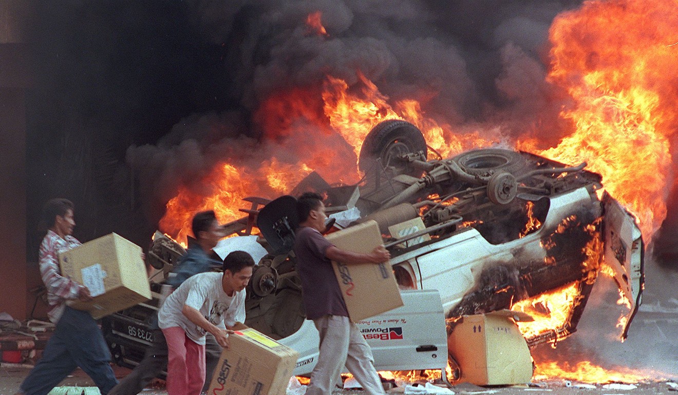Angry mobs burn cars and Chinese shops as they plunder shops in Jakarta in the riots of 1998. Photo: AFP