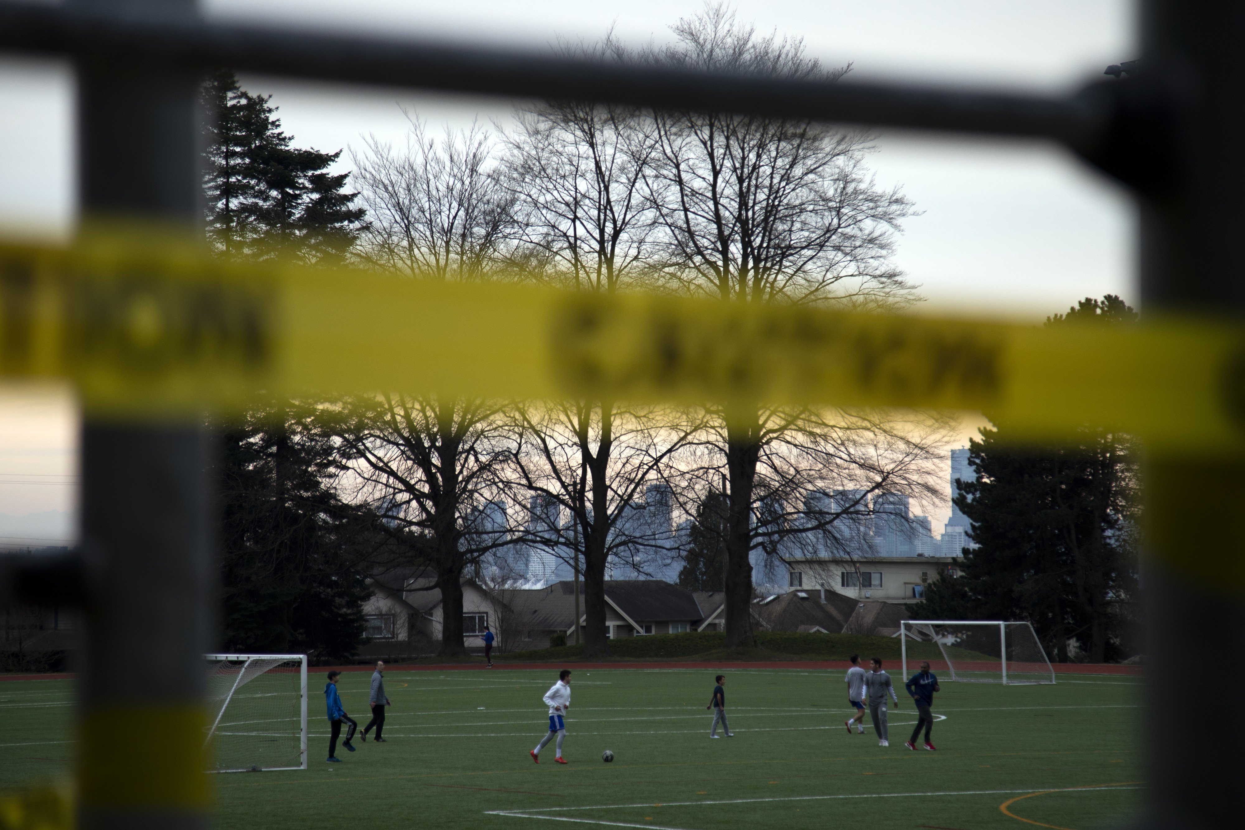 People play soccer behind caution tape at Mahon Park in North Vancouver, British Columbia, Canada. The Vancouver Park Board has closed all public outdoor recreation facilities within its parks, beaches, and parking lots because of a lack of public compliance with social distancing rules. Photo: Taehoom Kim/Bloomberg