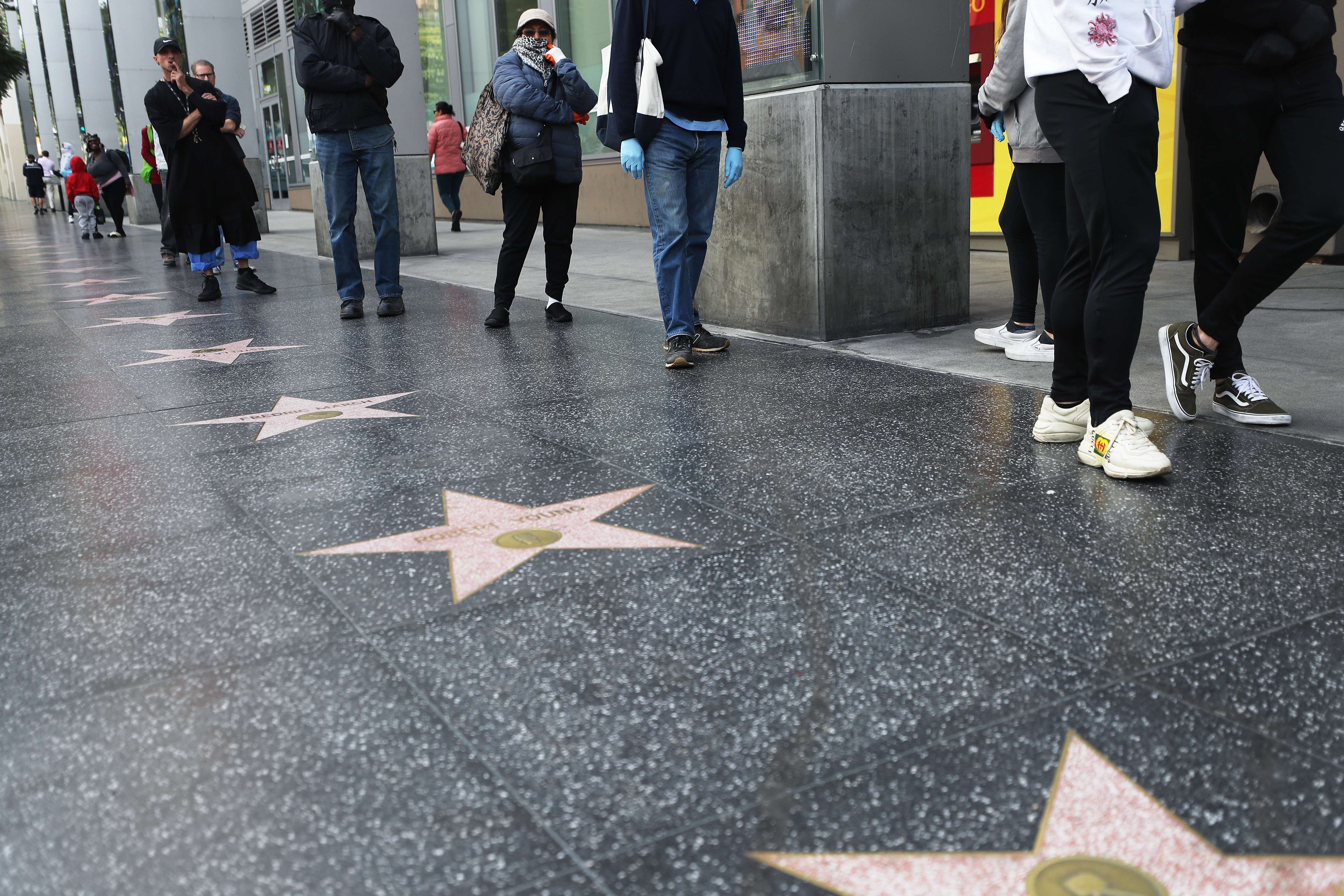 Customers maintain social distancing while standing in line Wednesday to enter a Trader Joe's supermarket along the Hollywood Walk of Fame, as the coronavirus pandemic expands in California. Photo: Getty Images via AFP