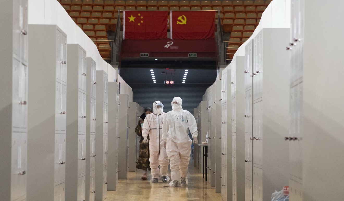 Medical staff in protective suits on their rounds at a Wuhan Fangcang hospital in a converted stadium. Photo: EPA-EFE