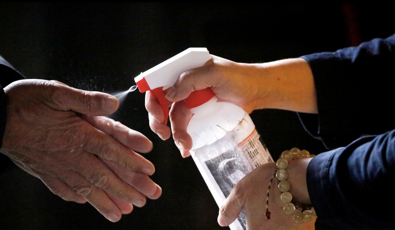 A devotee has his hands sanitised to protect himself from the coronavirus before entering Lungshan Temple in Taipei. Photo: Reuters