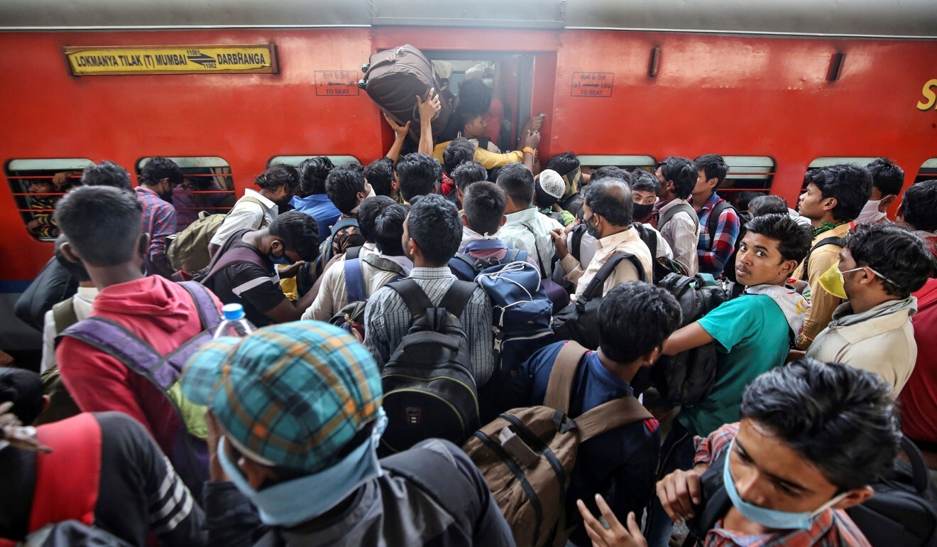Migrant workers and their families attempt to board an overcrowded train on March 21, before India’s nationwide lockdown came into effect. Photo: Reuters