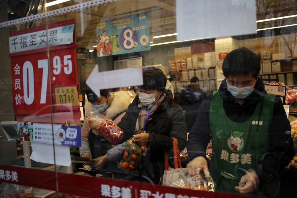 People wearing masks buy vegetables at a store in Beijing. Photo: EPA-EFE