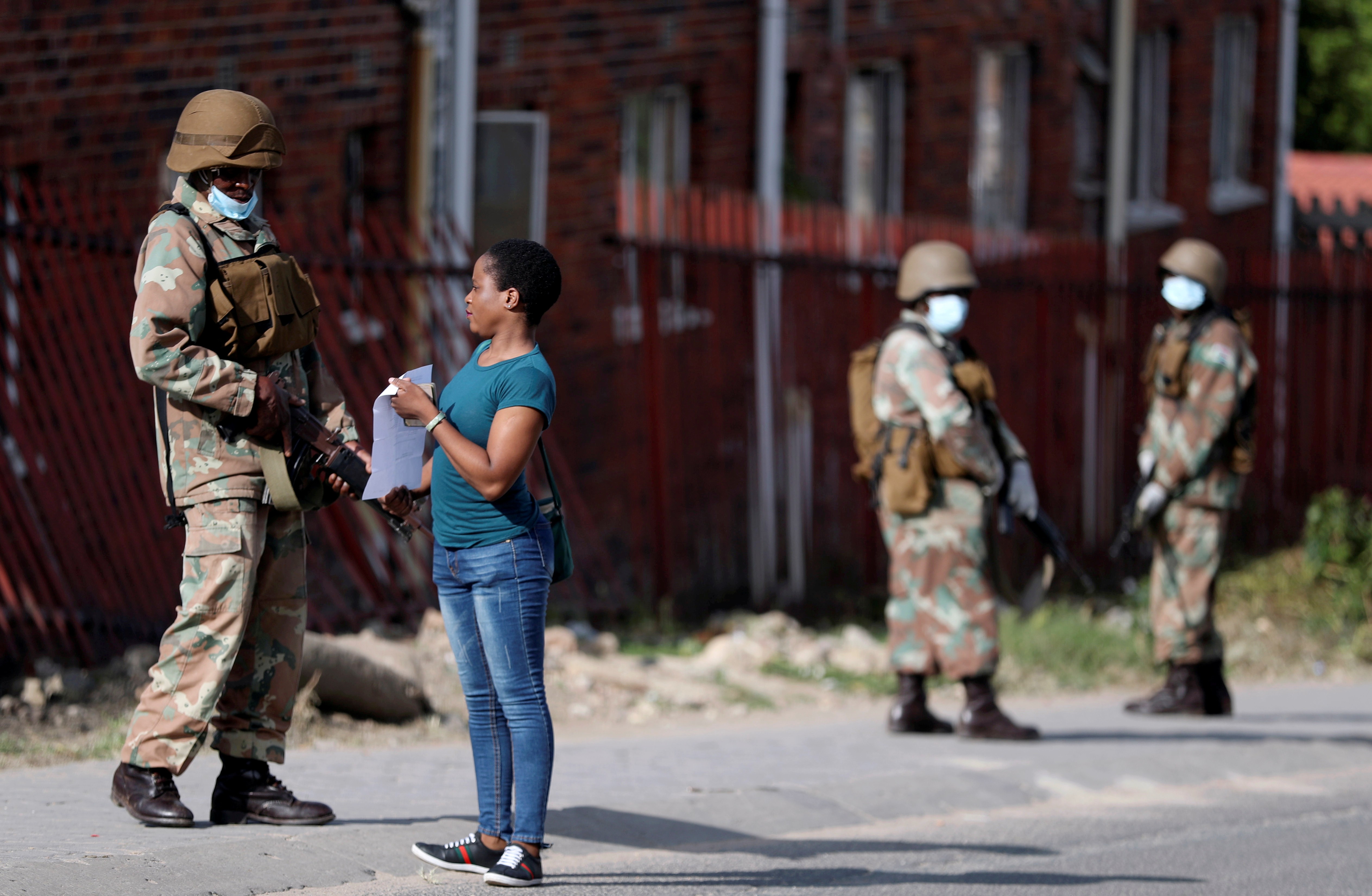 A South African soldier checks the documents of a resident of Alexandra township, as the military enforces a three-week nationwide lockdown in the country to stem the spread of the coronavirus pandemic. Photo: Reuters
