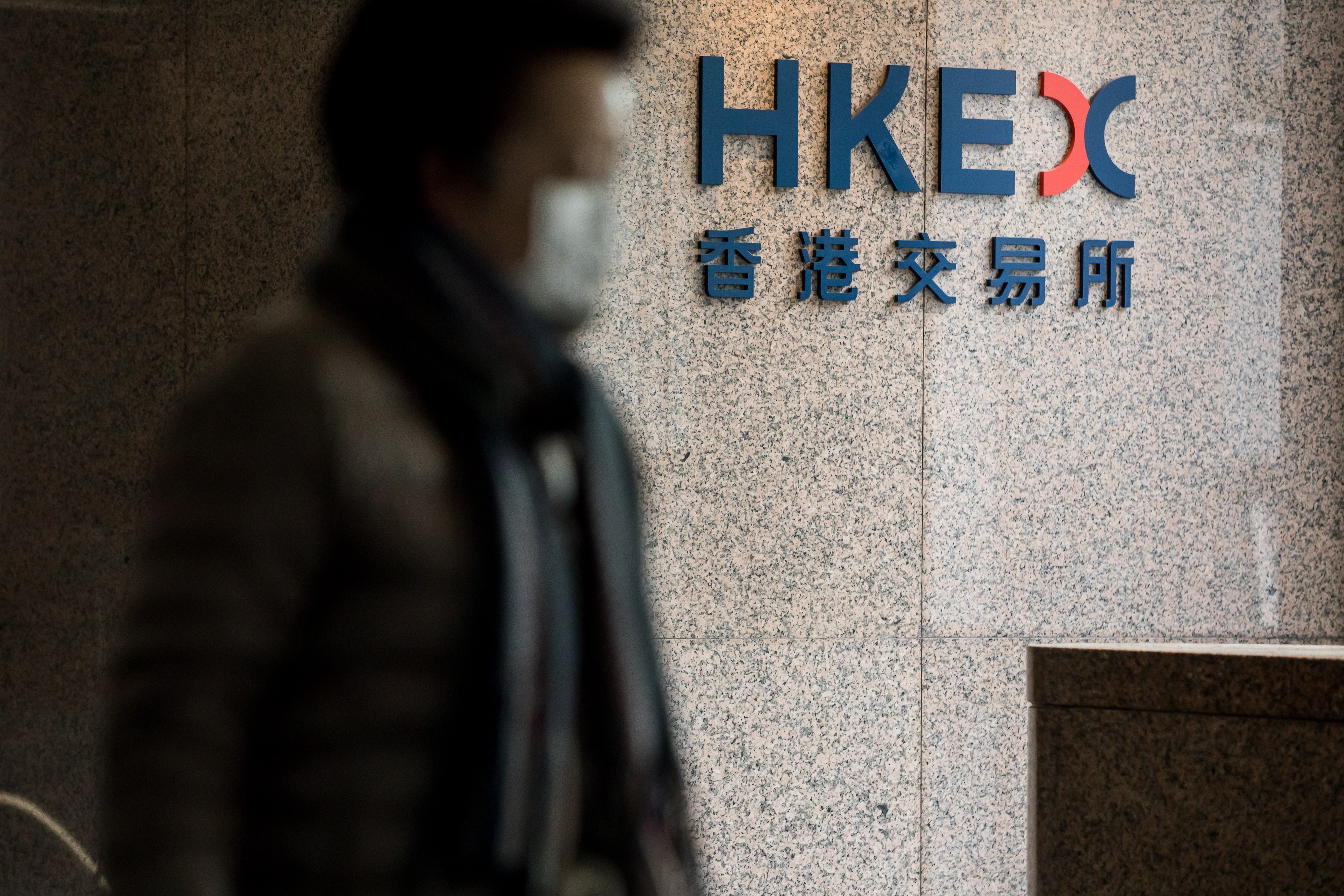 A man walks past a Hong Kong Exchanges & Clearing Ltd. (HKEX) signage at the Exchange Square complex in Hong Kong. Photo: Bloomberg