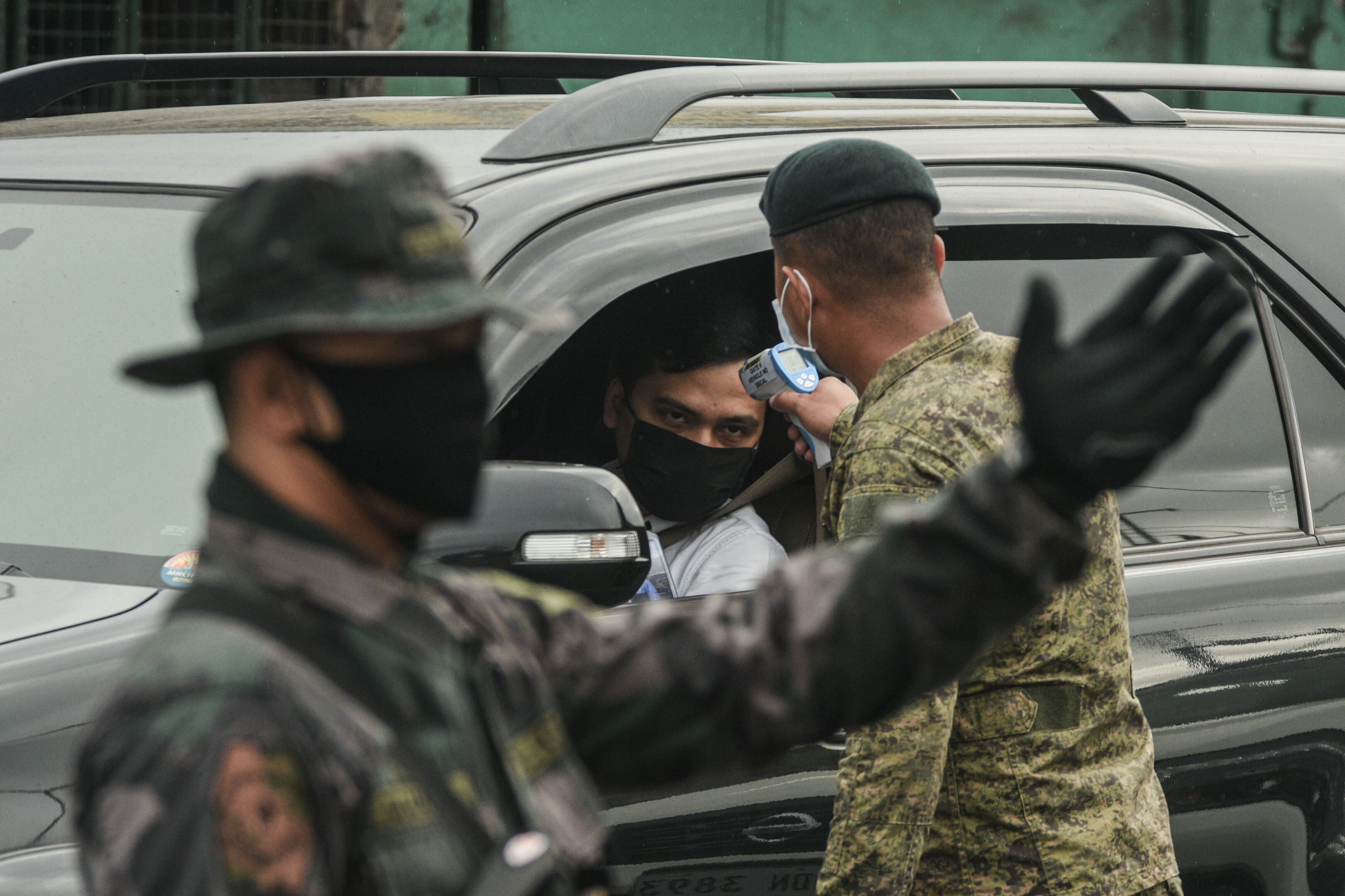 A soldier checks the temperature of a motorist at a coronavirus checkpoint near Manila on Monday. Photo: AFP