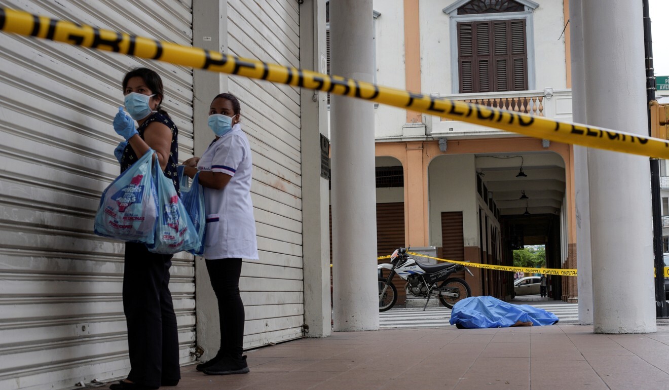 Women stand near the body of a man who died on the sidewalk in Guayaquil, Ecuador. Photo: Reuters