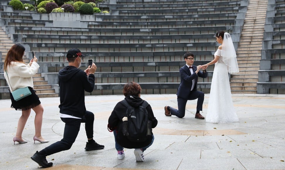 A couple getting their wedding picture taken in Central amid the latest move by the government to close cinemas, gyms and arcades. Photo: Nora Tam