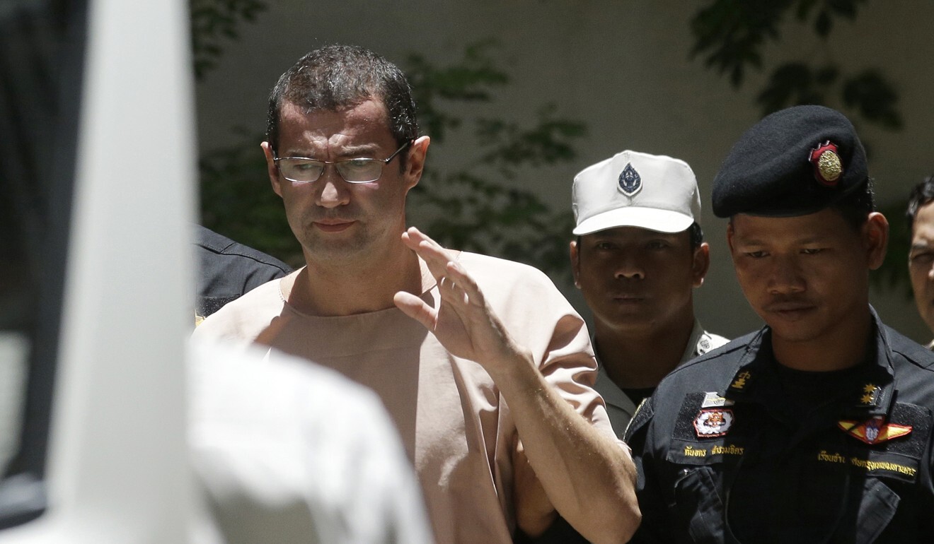 Xavier Justo es escoltado por oficiales de correccionales tailandeses cuando sale de un tribunal en Bangkok.  Sirvió más de un año en una prisión tailandesa después de ser condenado por chantaje vinculado al escándalo de 1MDB.  Foto: AP