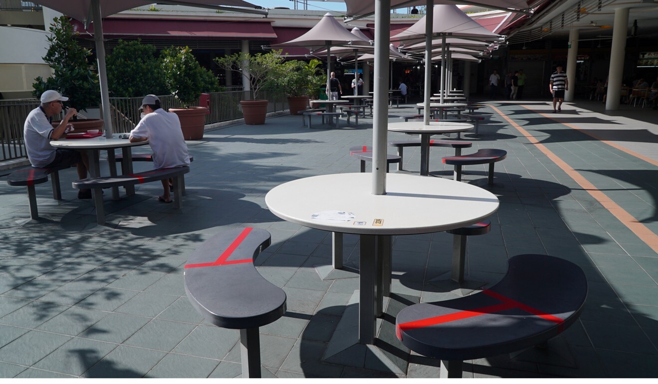 Seats are taped up at a food centre in Singapore to encourage social distancing. Photo: Reuters
