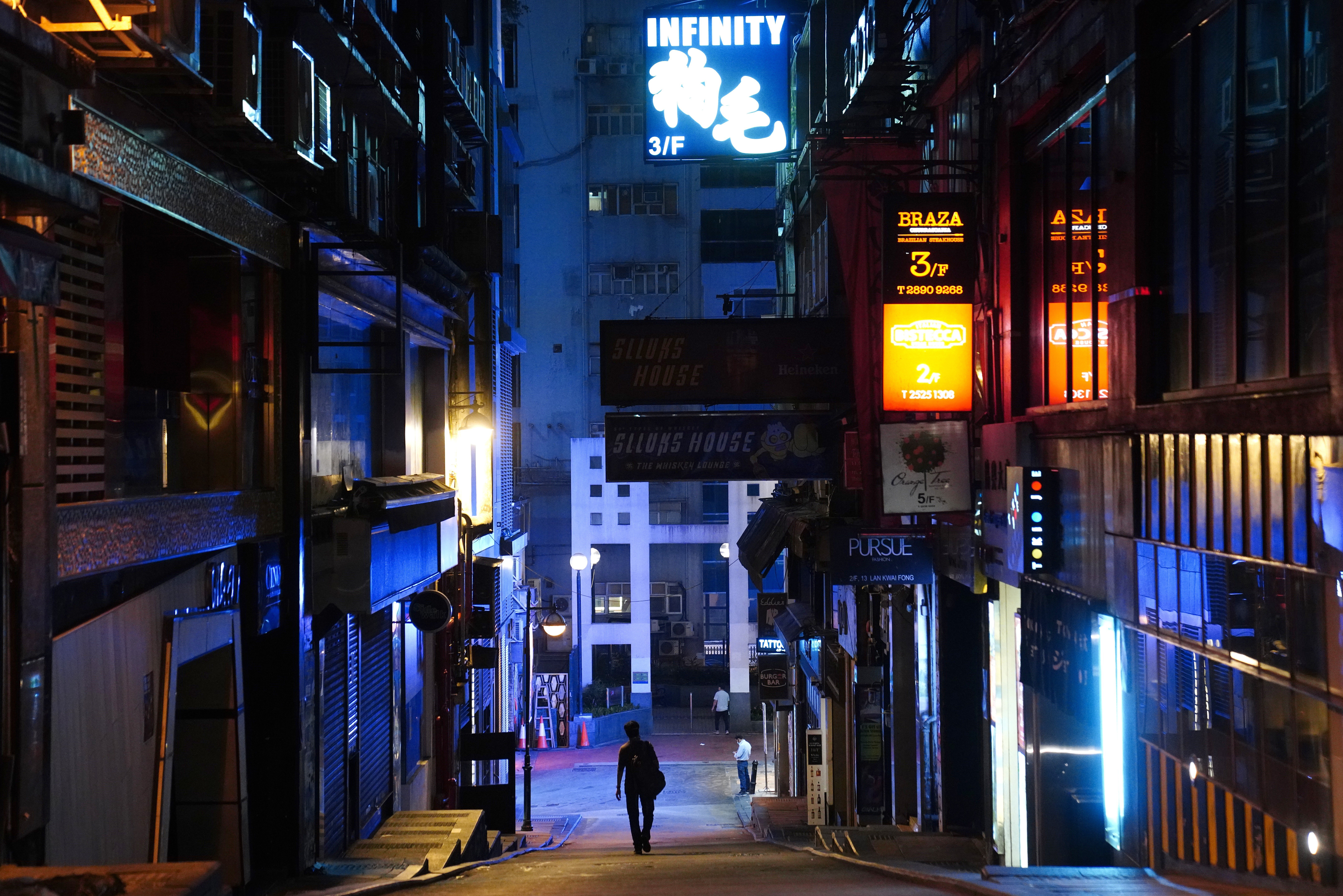 A man walks down a deserted street in the usually bustling nightlife district of Lan Kwai Fong in Central on March 27. The government has ordered a two-week shutdown of pubs and bars to contain the spread of Covid-19. Photo: Sam Tsang