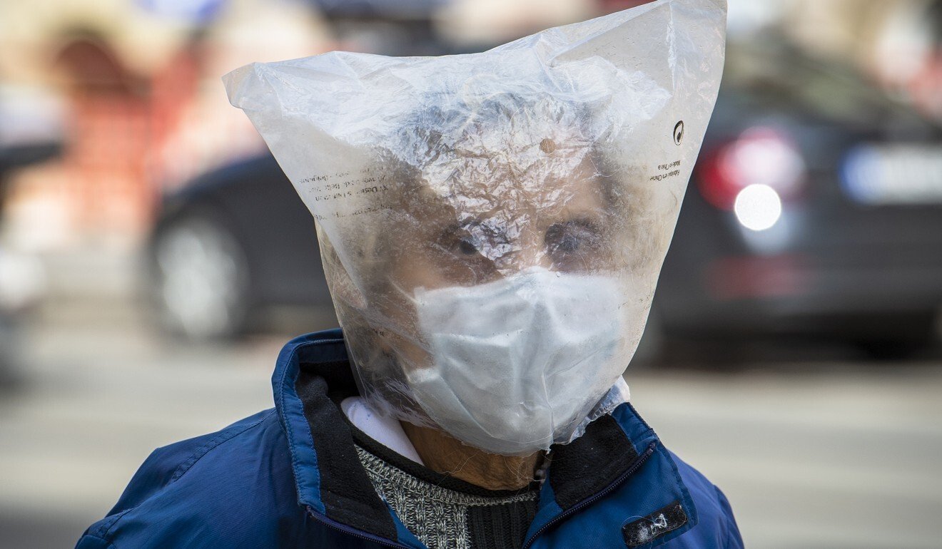 A woman wears a face mask and plastic bag over her head in the Czech Republic. Photo: Kateøina