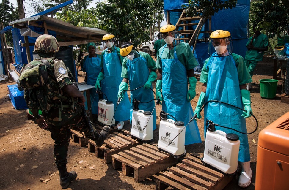 A United Nations peacekeeper has his shoes cleaned with a chlorine solution before leaving an Ebola treatment centre in the DRC’s North Kivu province. Photo: AFP