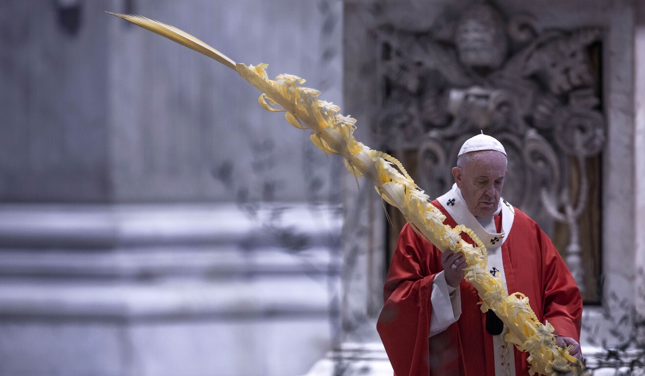 Pope Francis holds a palm branch as he celebrates Palm Sunday Mass behind closed doors in St Peter's Basilica. Photo: dpa