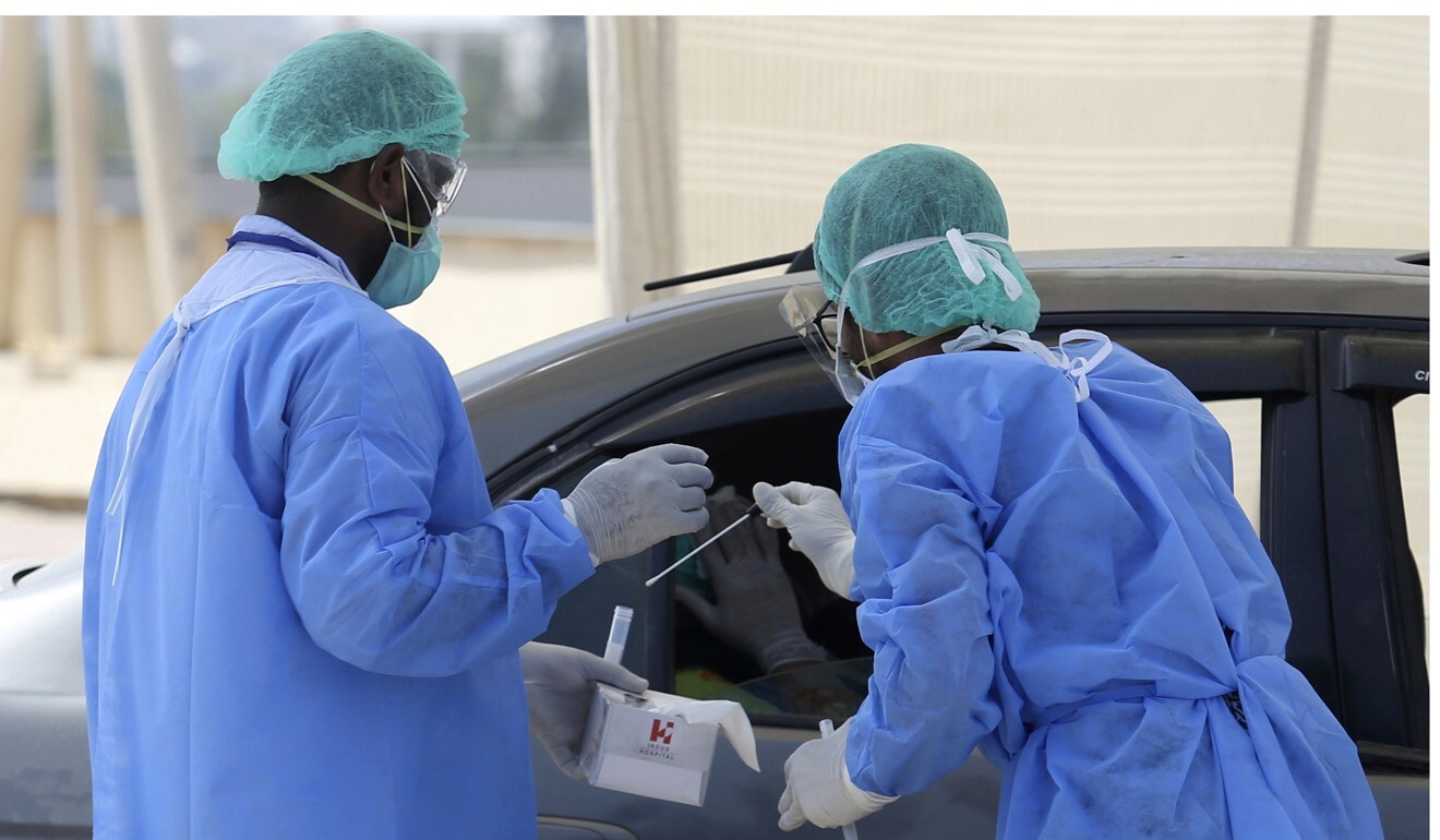 Health workers collect a specimen at a drive-through testing and screening facility for the coronavirus, in Karachi, Pakistan. Photo: AP