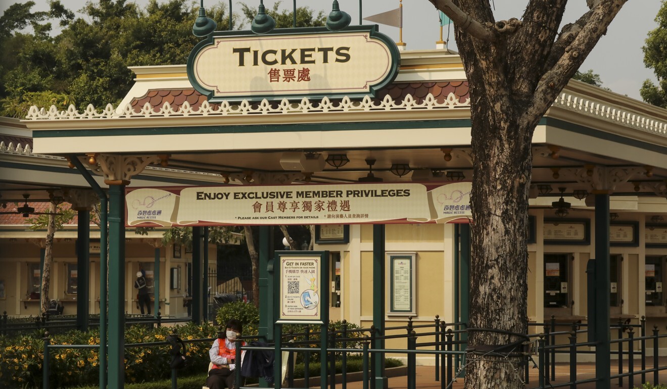 An employee sits behind the closed gates of an empty Hong Kong Disneyland in late March. Photo: K.Y. Cheng