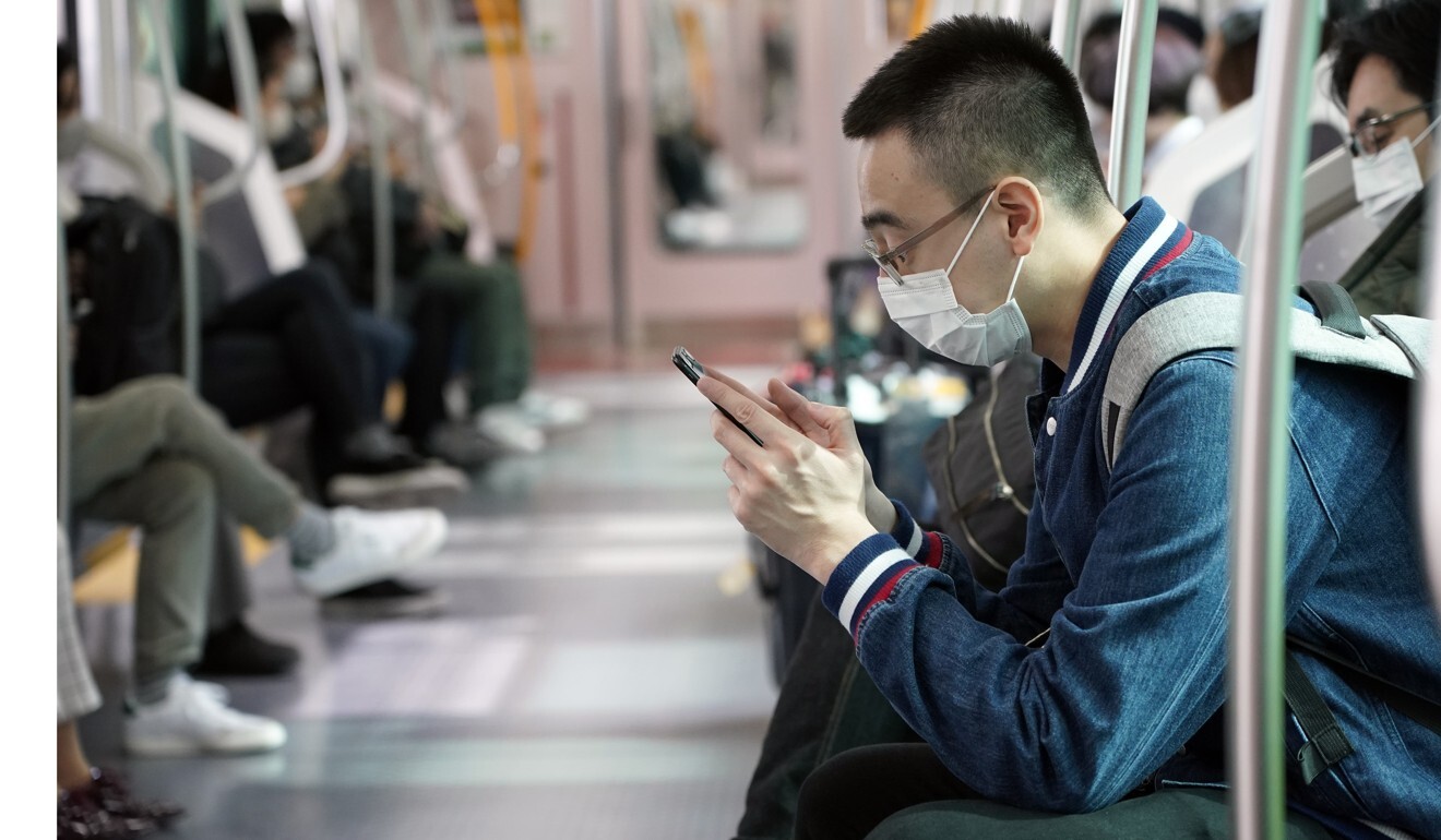 A man wearing a face mask sits in a train in Tokyo, where there has been a spike in infections. Photo: EPA-EFE