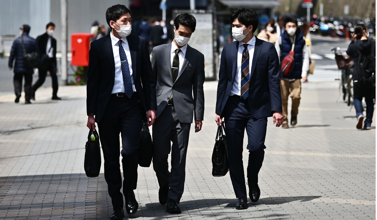 People wearing face masks walk in Tokyo's Gotanda area. Photo: AFP