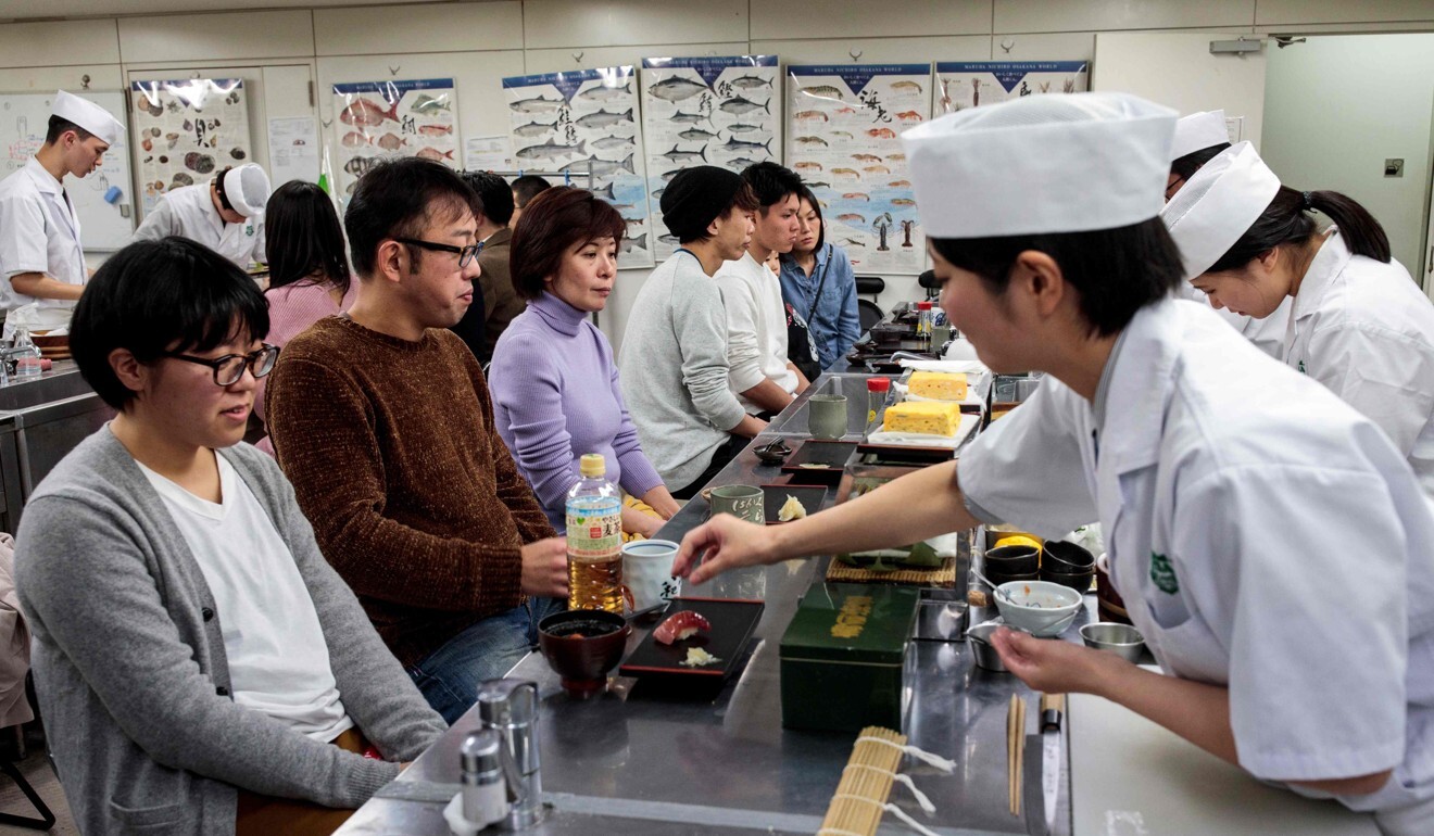 Yuki Noguchi, right, a student at Tokyo Sushi Academy, practises serving sushi. Photo: AFP