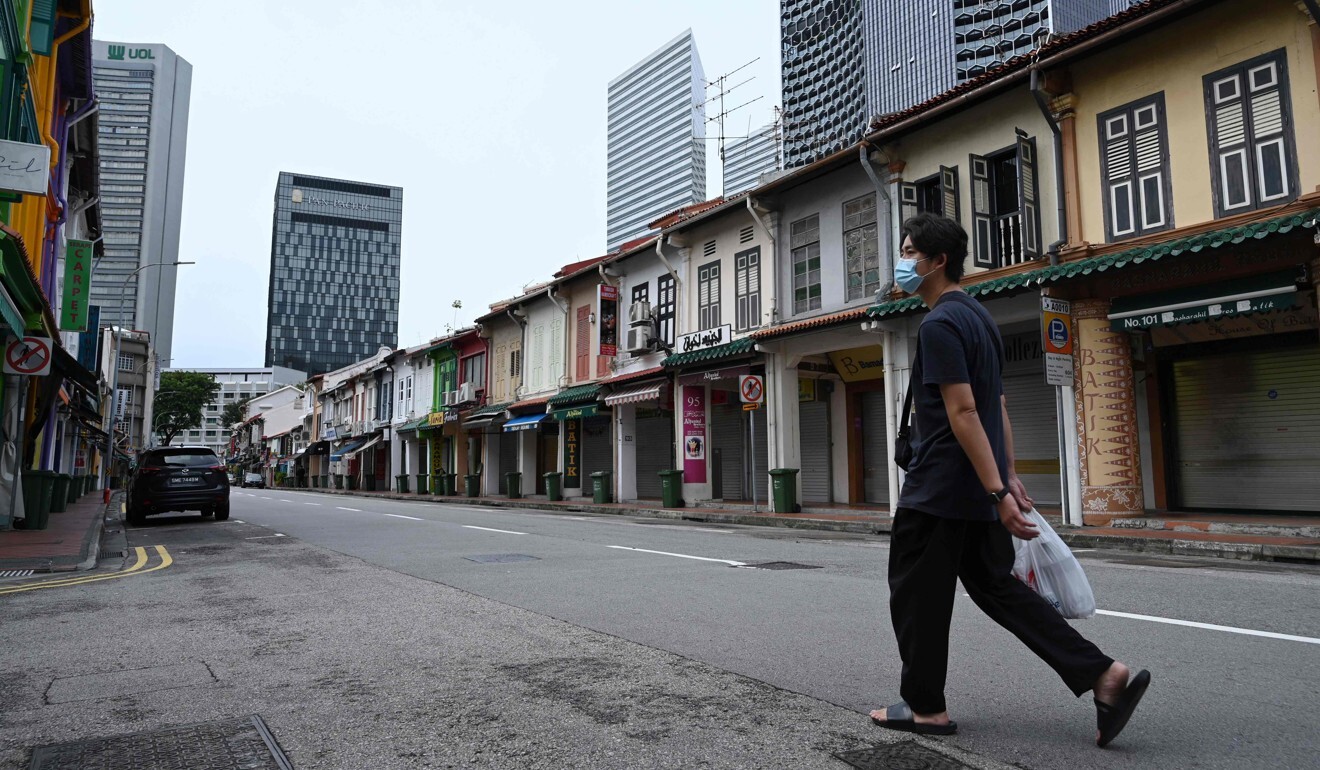 A man walks along a street with closed shops on April 7, 2020. Photo: AFP