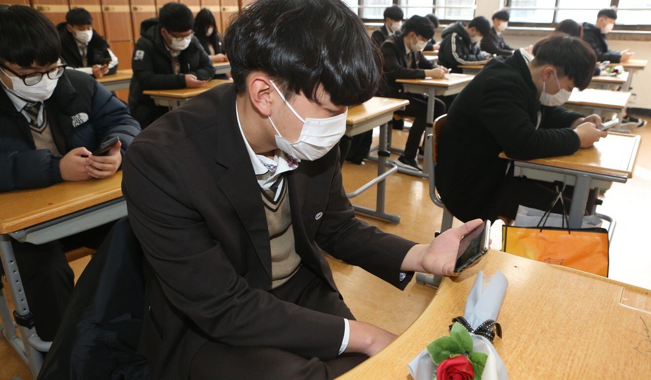 South Korean students watch a small-scale graduation ceremony via YouTube after their school cancelled a graduation ceremony at its auditorium and decided to hold a scaled-down version amid fears over the spreading coronavirus. Schools are now shut. Photo: DPA