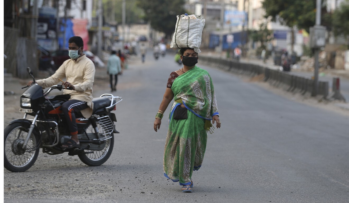 An Indian woman walks with vegetables from a market in Hyderabad, India, during the lockdown to prevent the spread of Covid-19. Photo: AP
