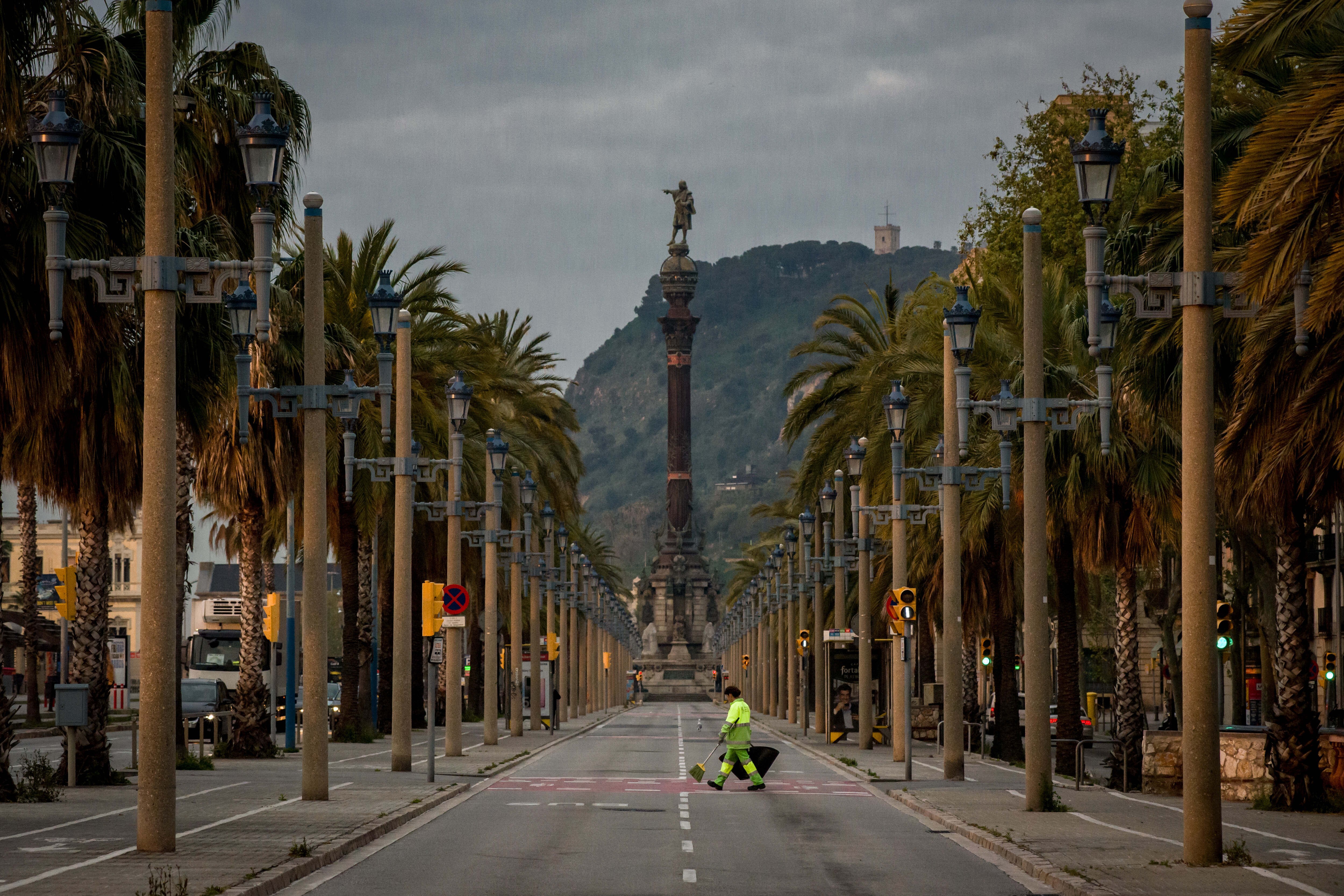 A Barcelona avenue is empty except for a cleaning worker during a nationwide lockdown to curb the spread of the coronavirus. Photo: DPA