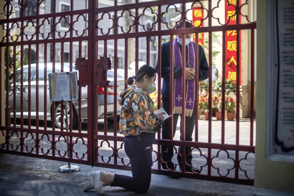 A priest listens to confessions through the fence of Our Lady of Lourdes Chapel church before Easter Holy Mass in Guangzhou, Guangdong province on Easter Sunday. Because of Covid-19, Guangzhou government banned all gatherings, so Catholics gathered in front of the church to celebrate. Photo: EPA-EFE