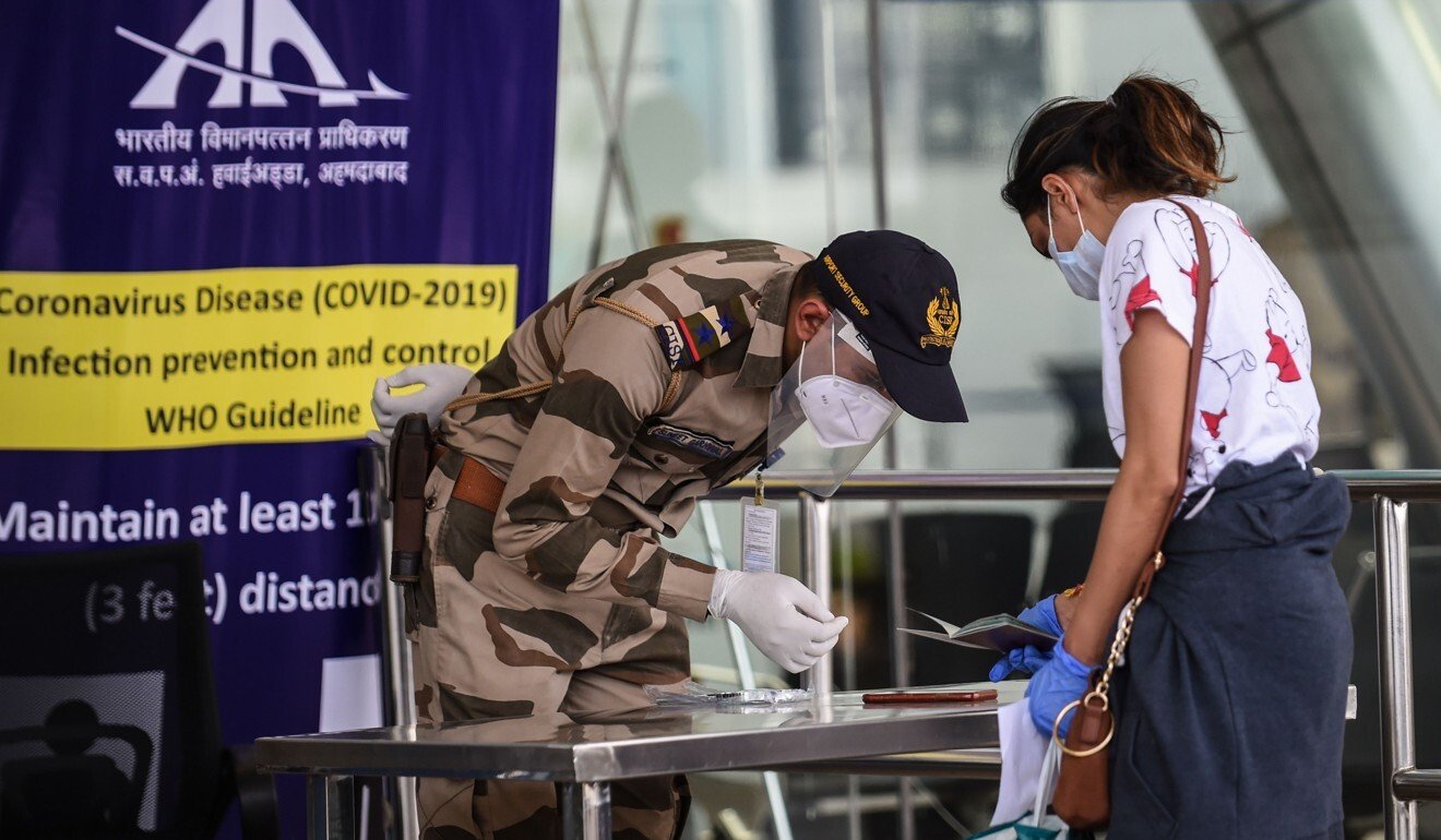 An armed policeman checks the documents of traveller boarding a special flight from Ahmedabad on Monday amid India’s nationwide lockdown. Photo: AFP