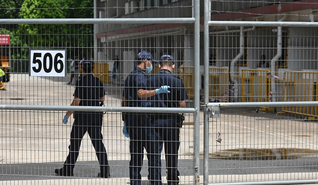 Police officers enter the gate of a dormitory compound for foreign workers placed under quarantine to battle the spread of Covid-19. Photo: AFP