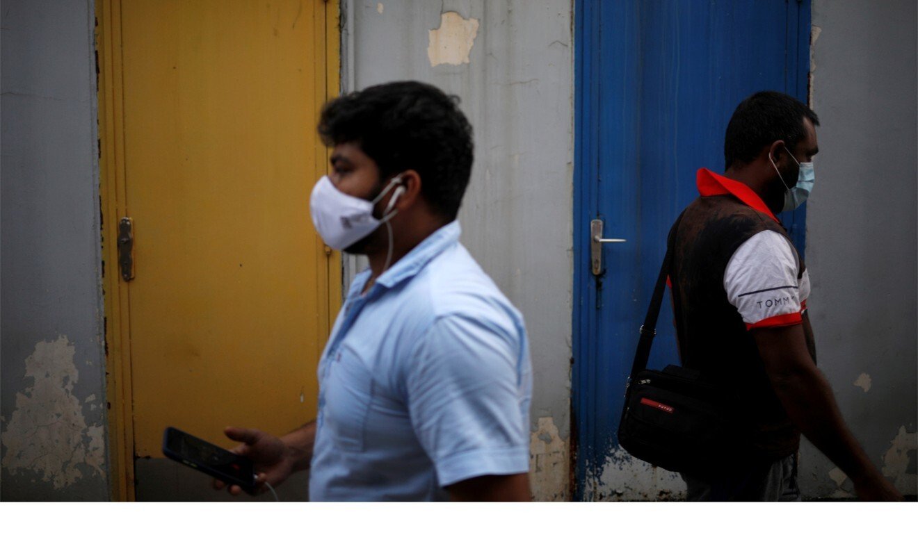 Migrant workers wearing face masks walk through Little India district in Singapore. Photo: Reuters