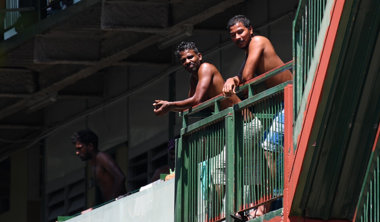 Men look out from the balcony of a dormitory used by foreign workers in Singapore. Photo: AFP