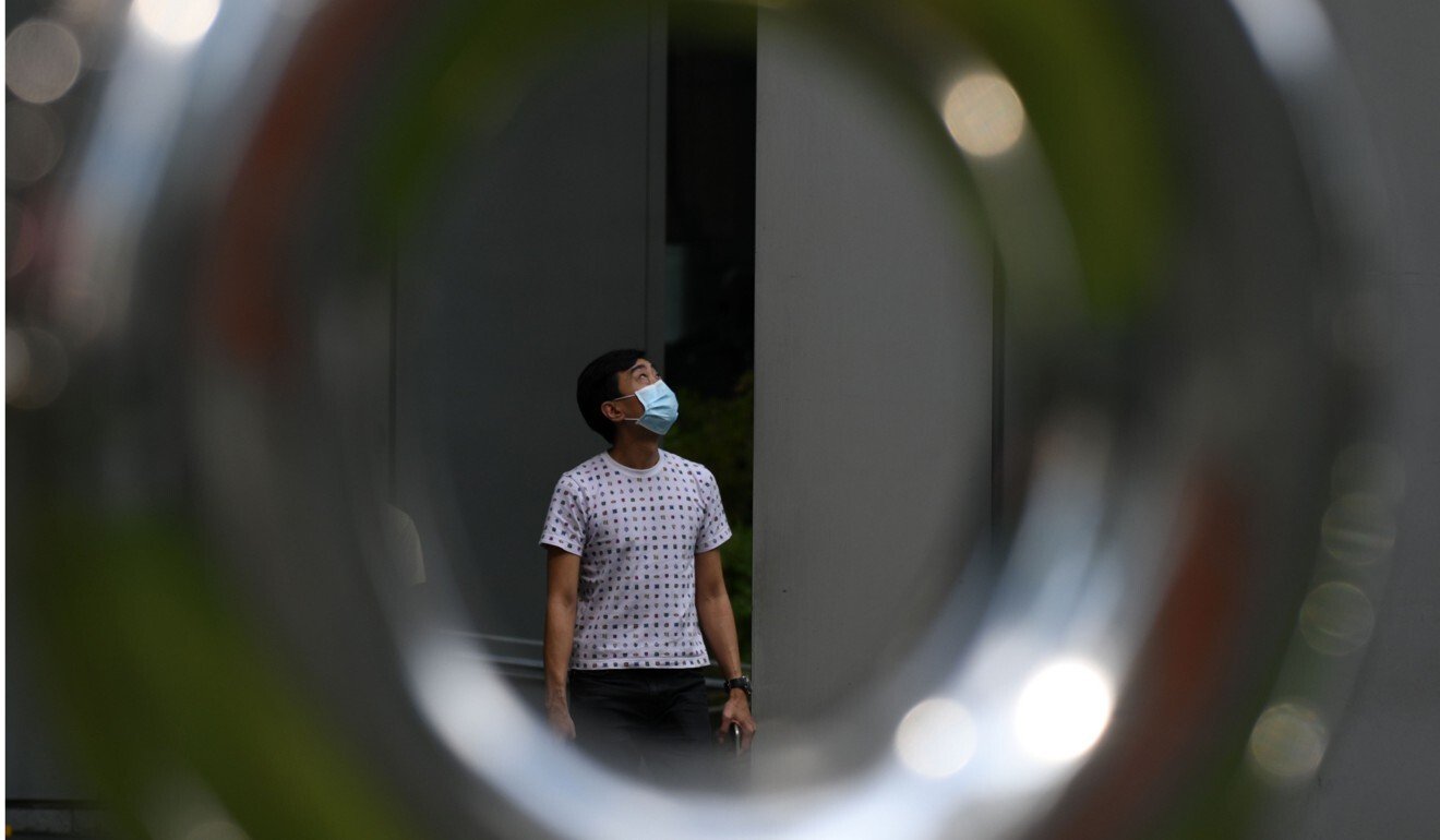 A man wearing a protective face mask walks in the Raffles Place financial business district in Singapore. Photo: AFP