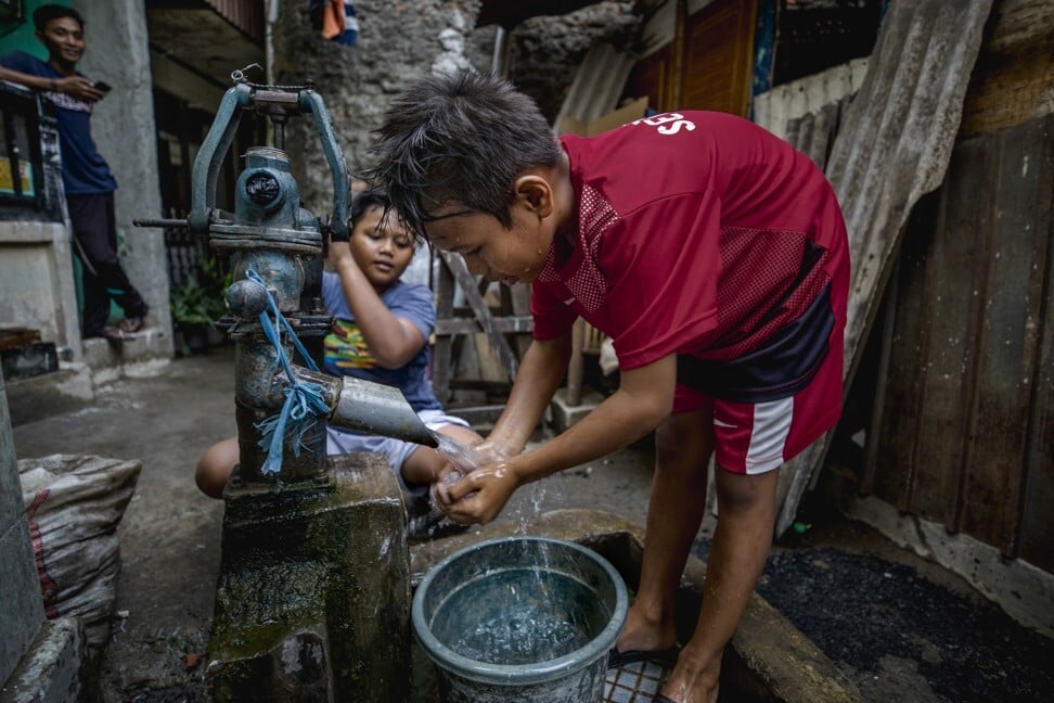 Children pump groundwater in a slum in Jakarta. Photo: Jonas Gratzer