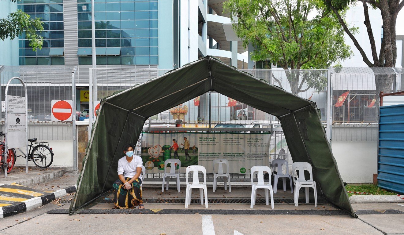 A migrant worker waits to get a medical check near the Toh Guan Dormitory on April 8. Photo: Xinhua
