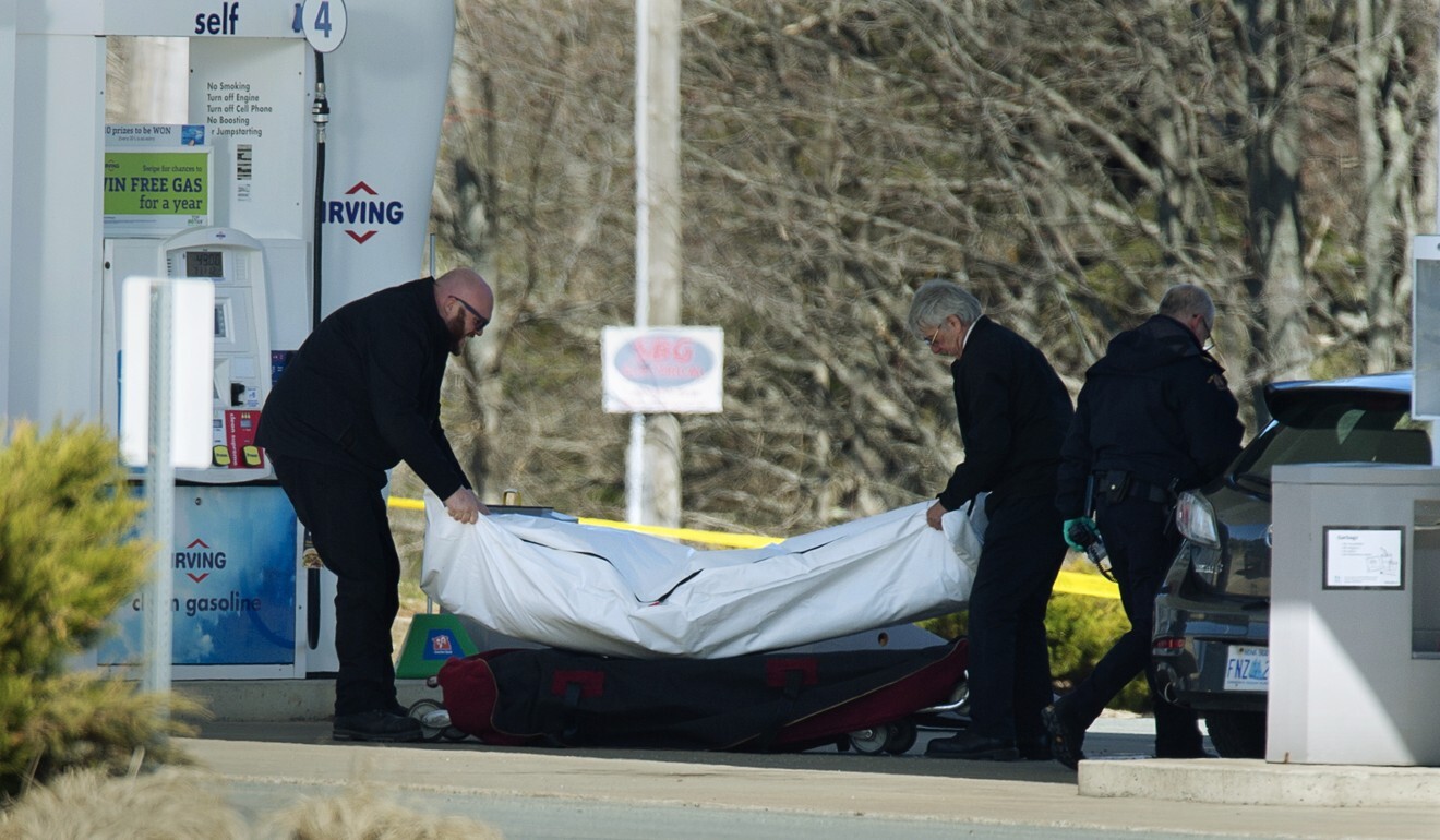 Workers with the medical examiner's office remove a body from petrol station in Enfield, Nova Scotia. Photo: AP