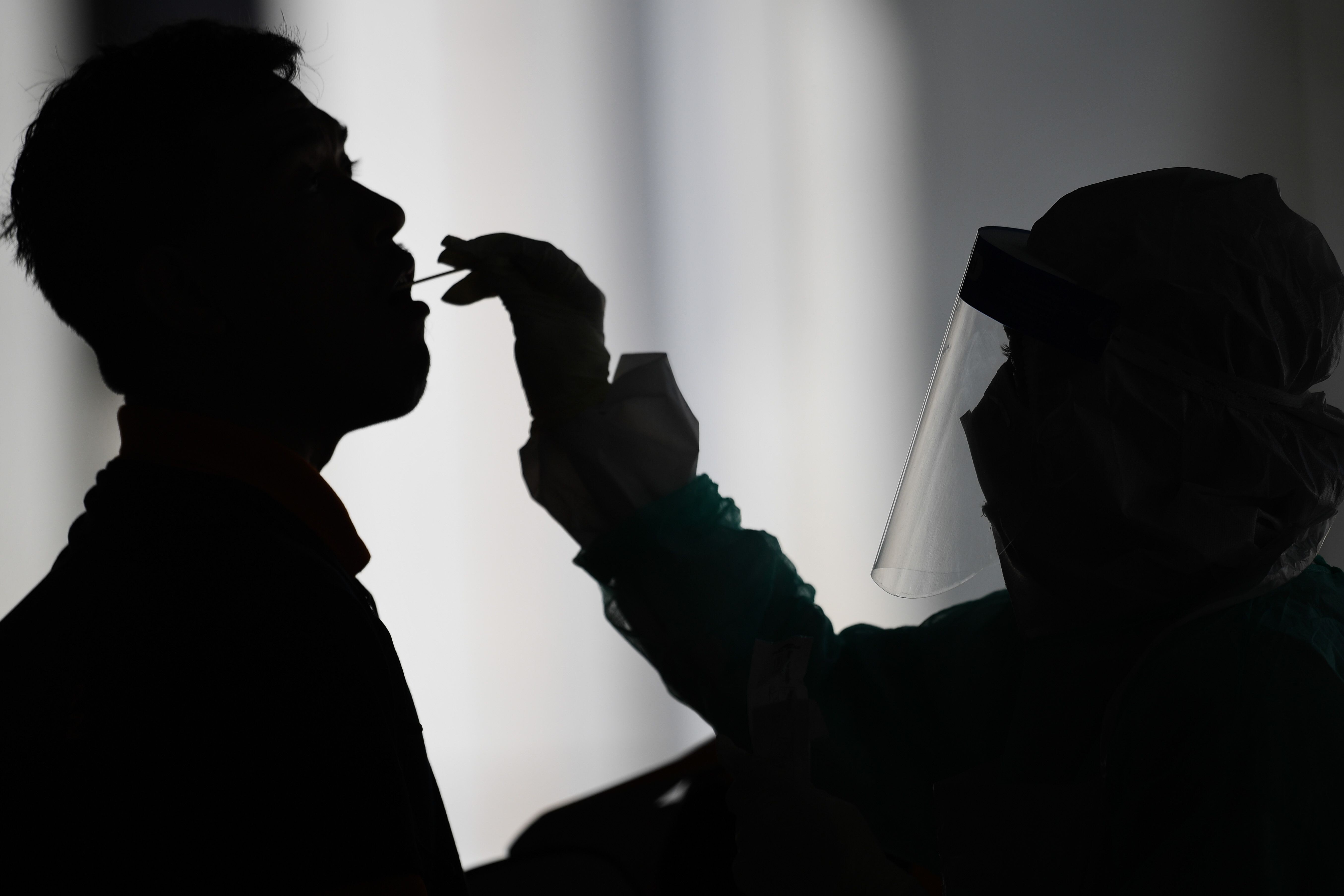 A health worker uses a swab to collect a sample for coronavirus testing. Photo: AFP