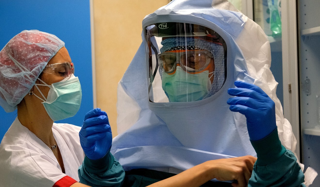 A nurse helps a colleague at a hospital in Rome. Photo: AP