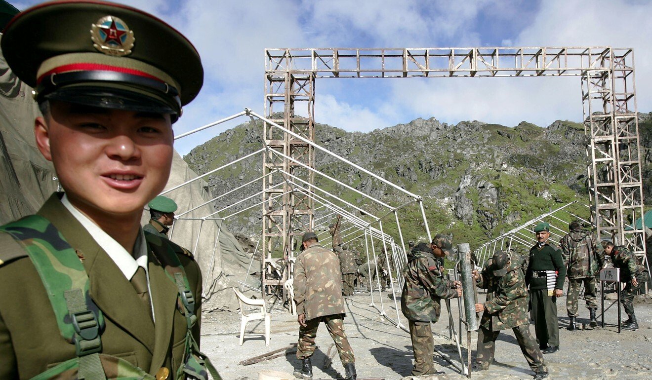 A Chinese soldier stands guard while Indian soldiers work near their shared border. Photo: AP