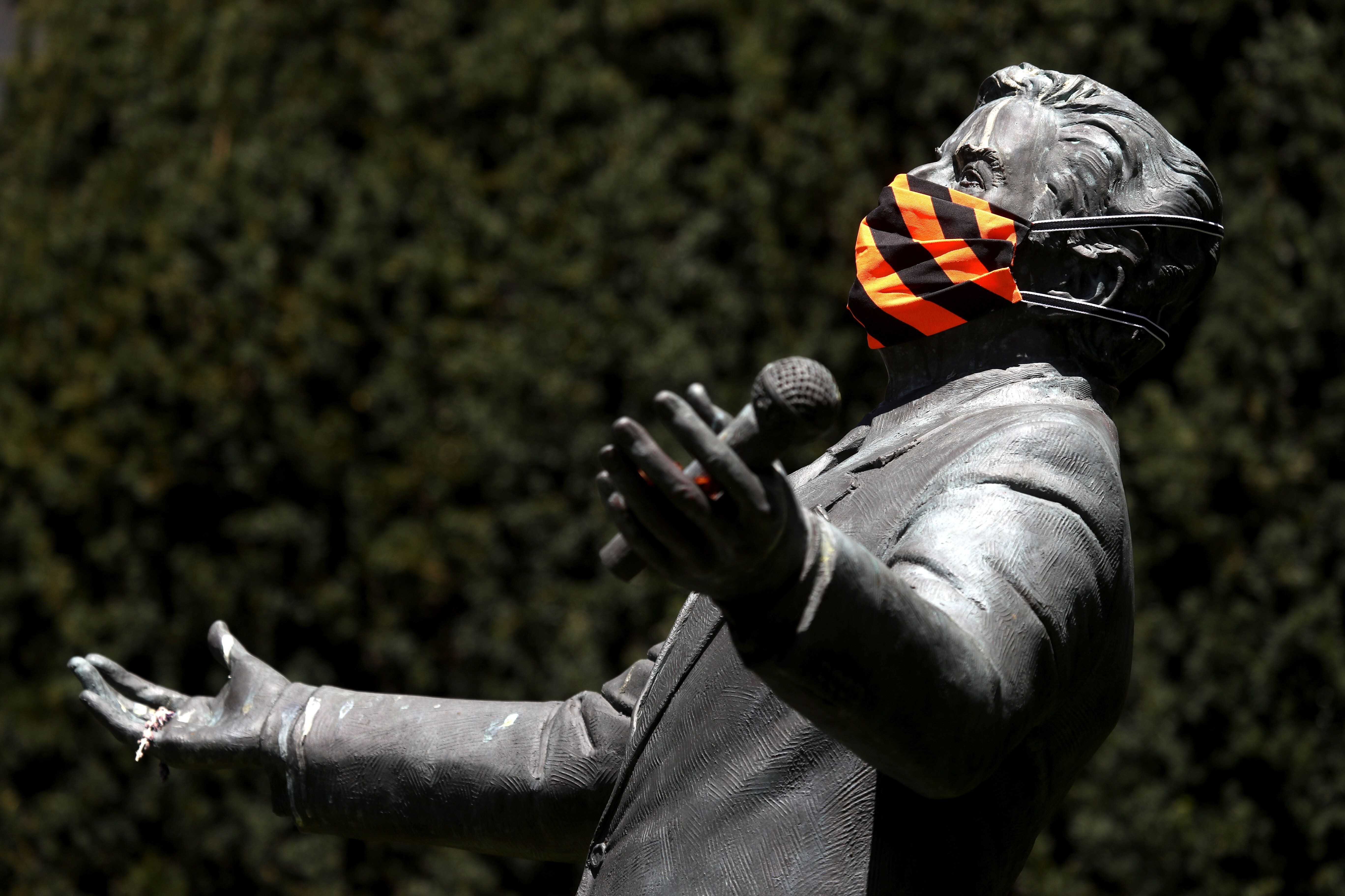 A protective mask is displayed on a statue of singer Tony Bennett in San Francisco on Wednesday. Photo: Getty Images via AFP